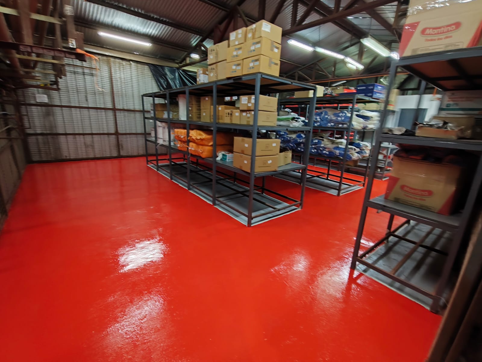 Piso industrial rojo continuo bajo estanterías de carga pesada